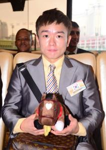 Seo Seung Un poses with a doll and some Louis Vuitton in Macau yesterday (Pic: Macau Jockey Club)