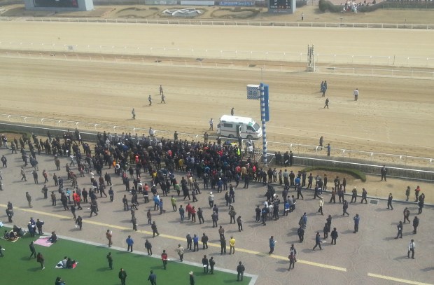 Protesters crowd around the winning line attempting to get onto the track